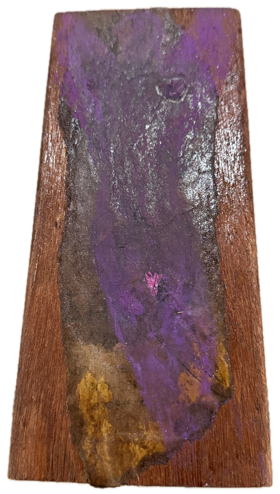 a long board washed in purple over red-brown wood