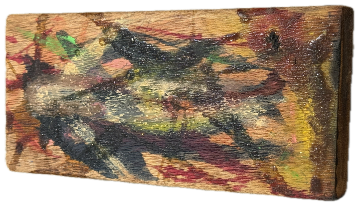 a block of wood worked in green, red and yellow over the grain